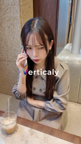 スマホで話す女性、カフェにて