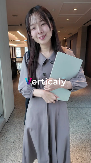 PCを持つ女性、笑顔で歩く