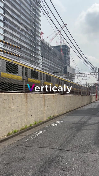 都会の線路沿い、電車が行く