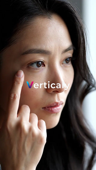 指で頬に触れる女性