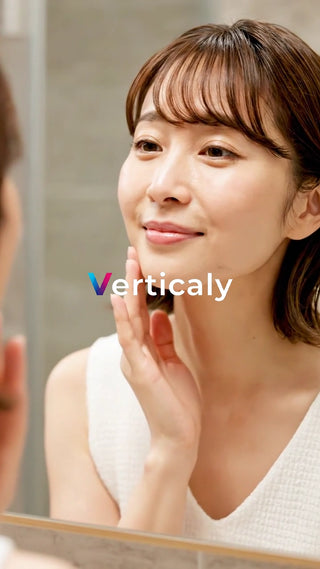 肌を触る女性、鏡越し