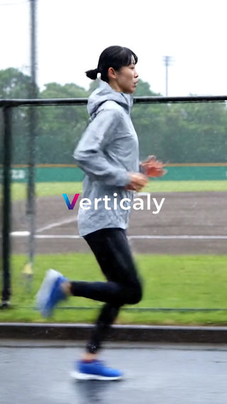 雨の中を走る女性