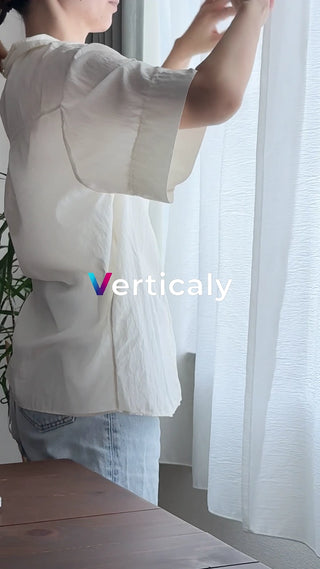 カーテンを開ける女性