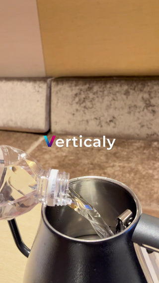 Pouring water into a black kettle