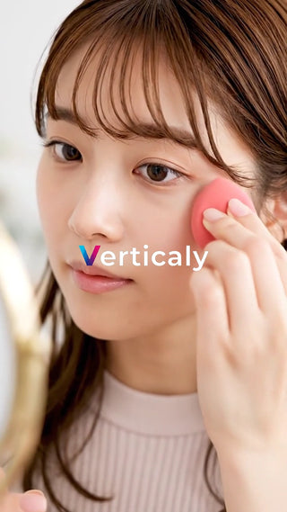 頬にファンデを塗る女性